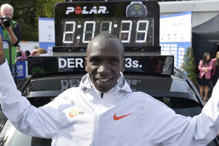 Pelari asal Kenya, Eliud Kipchoge, merayakan catatan waktu rekor dunia yang ia torehkan di Berlin Marathon, Minggu (16/9/2018).