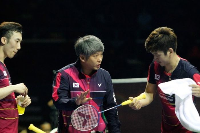Pelatih bulu tangkis nasional Korea Selatan, Kang Kyung-jin (tengah), memberi instruksi kepada pasangan ganda putra Lee Yong-dae/Yoo Yeon-seong, saat menjalani pertandingan pada turnamen Singapura Terbuka 2016.