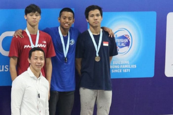 Perenang putra Indonesia, Aflah Fadlan Prawira (tengah) berpose di podium setelah meraih emas dari nomor 200 meter gaya bebas putra di Aquatic Stadium, GBK, Senayan, Jakarta, Senin (3/12/2018).