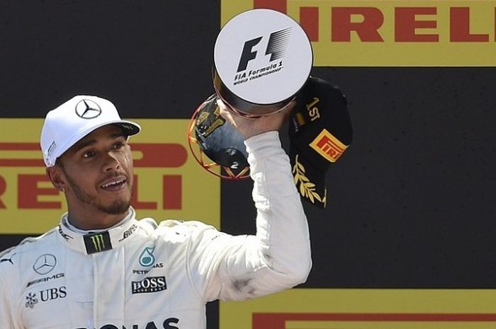 Pebalap Mercedes, Lewis Hamilton, melakukan selebrasi seusai memenangi balapan GP Spanyol di Circuit de Barcelona-Catalunya, Minggu (14/5/2017).