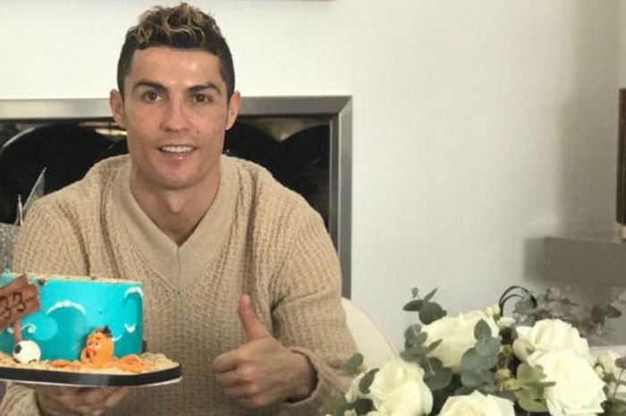 Cristiano Ronaldo memegang kue ulang tahun di hari ulang tahunnya