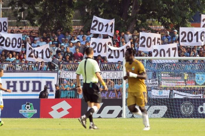 Penonton laga Persela Vs Persib membawa poster bertuliskan angka yang berupa tahun karier Choirul Huda bersama tim yang ditinggalkan pada laga pekan ke-31 Liga 1 musim 2017 di Stadion Surajaya, Lamongan, Minggu (22/10/2017). 