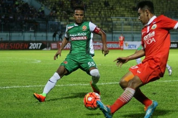 Winger Persija, Abrizal Umanailo (kanan) coba dihadang pemain bertahan PS TNI, Manahati Lestusen pad