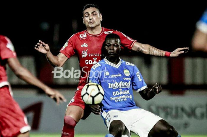    Ezechiel NDouassel dijaga ketat Jaimerson da Silva Xavier pada laga Persija kontra Persib Bandung di Stadion PTIK, Jakarta, Sabtu (30/6/2018).   