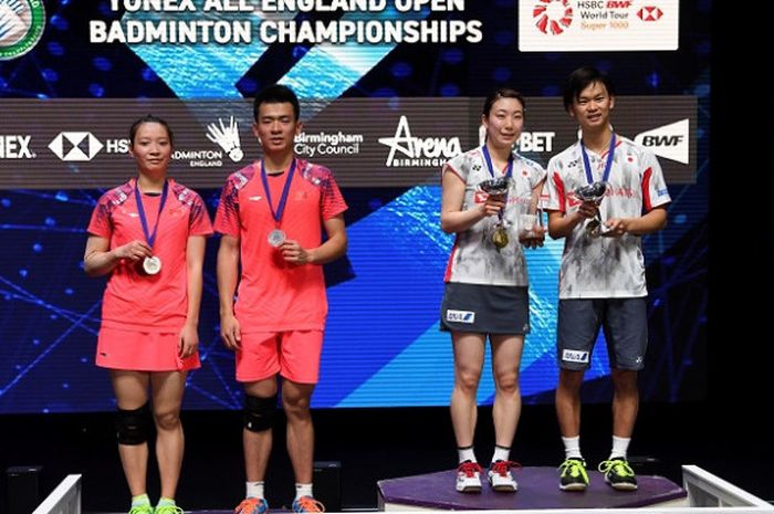 Pasangan ganda campuran Jepang, Yuta Watanabe/Arisa Higashino, berpose dengan trofi yang didapat sebagai juara All England 2018 setelah mengalahkan wakil China, Zheng Siwei/Huang Yaqiong, 15-21, 22-20, 21-16, pada partai final yang digelar di Arena Birmingham, Inggris, Minggu (18/3/2018).