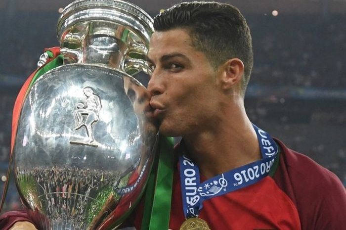 Kapten Portugal, Cristiano Ronaldo, mencium trofi Piala Eropa di Stade de France, Minggu (10/7/2016).