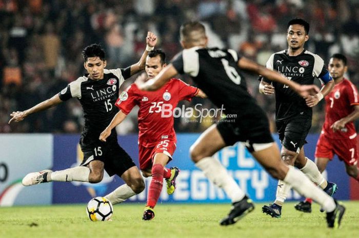  Pemain Persija, Riko Simanjuntak, mengontrol bola pada laga Piala AFC 2018 kontra Home United di St