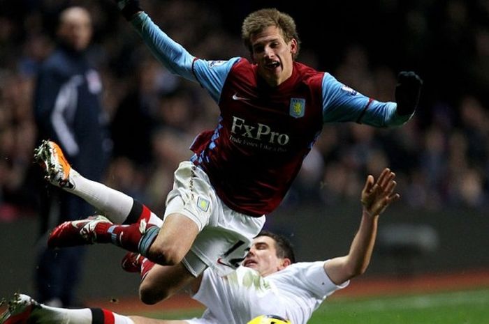 Marc Albrighton (Aston Villa, atas) terjatuh ketika menerima tekel dari Aleksandar Kolarov dalam duel Premier League lawan Manchester City, 22 Januari 2011.