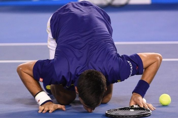 Petenis Serbia, Novak Djokovic, mencium lantai Rod Laver Arena, Melbourne Park, setelah meraih kemenangan pada laga final Australia Terbuka atas petenis Inggris Raya, Andy Murray, Minggu (11/1/2016).