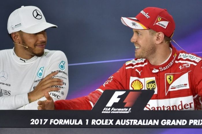 Pebalap Mercedes, Lewis Hamilton (kiri), mendengarkan ucapan pebalap Ferrari, Sebastian Vettel, di sela konferensi pers setelah balapan GP Australia di Sirkuit Melbourne Grand Prix, Albert Park, Minggu (26/3/2017), berakhir. Vettel tampil sebagai juara, sedangkan Hamilton finis kedua.