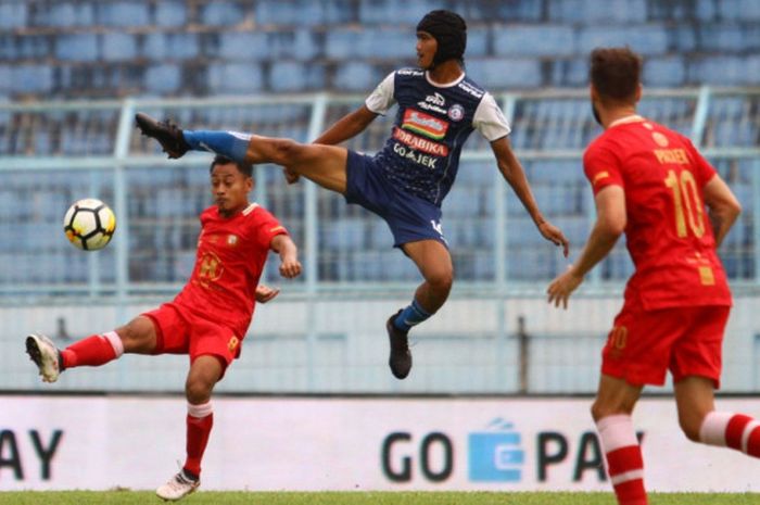 Gelandang Arema FC, Jayus Hariono berebut  bola dihalangi striker  Barito Putera, Samsul Arif dalam lanjutan Liga 1 di Stadion Kanjuruhan Kepanjen, Kabupaten Malang, Sabtu (24/11/2018). 