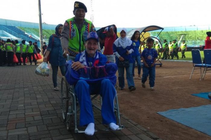 Brigadir Polisi Bambang Cahyono tampak antusias mendorong kursi roda yang dinaiki oleh Paul Cumming saat berjalan menuju tribune Stadion Kanjuruhan, Kabupaten Malang pada Sabtu (12/87/2017). 