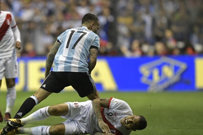 Pemain Peru, Paolo Guerrero, terjatuh dekat bek Argentina, Nicolas Otamendi, dalam laga Kualifikasi Piala Dunia 2018 Zona Amerika Selatan di Buenos Aires, Argentina, pada 5 Oktober 2017.
