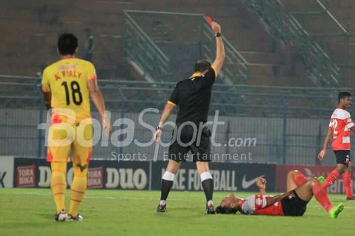 Wasit asing Seyed Vahitd Kazem asal Iran memberikan kartu kuning pada pemain Madura United saat melawan Bhayangkara FC, Rabu (8/11/2017) malam.