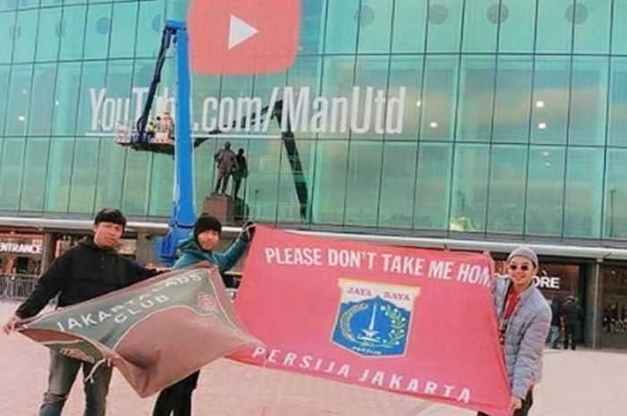 Bastian Steel Mengibarkan bendera Persija Jakarta bersama dua orang rekannya di depan Stadion Old Trafford