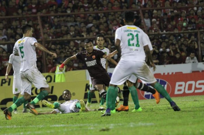 Penyerang PSM Makassar, Ferdinand Sinaga (tengah) di antara tujuh pemain Persebaya yang menjaganya pada lanjutan Liga 1 2018 di Stadion Andi Mattalatta, Kota Makassar, 9 Juni 2018. 