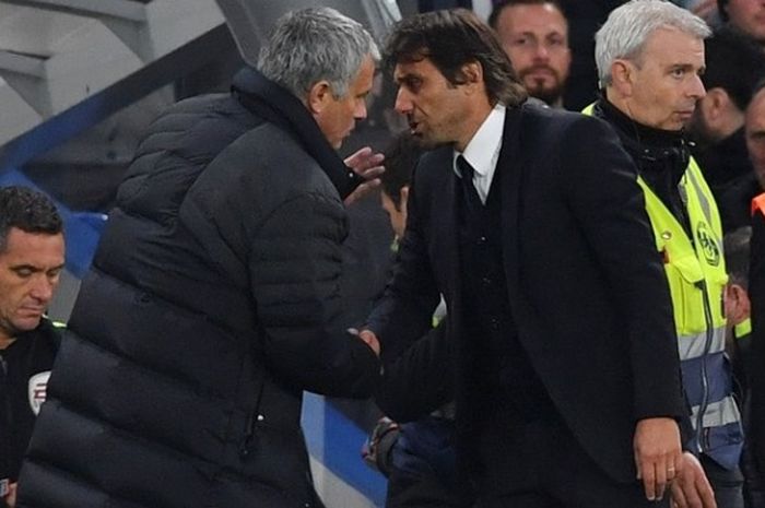 Manajer Manchester United, Jose Mourinho, membisikkan sesuatu kepada koleganya di Chelsea, Antonio Conte, setelah duel kedua tim pada partai Premier League di Stadion Stamford Bridge, Minggu (23/10/2016).