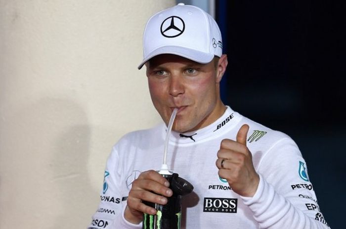  Pebalap Mercedes, Valtteri Bottas, mengacungkan jempol seraya minum sesaat setelah meraih pole position perdana sepanjang karier balapan Formula 1 (F1) pada GP Bahrain. Bottas mencatat waktu putaran tercepat 1 menit 28,769 detik pada sesi kualifikasi di Sirkuit Internasional Bahrain, Sakhir, Sabtu (15/4/2017). 
