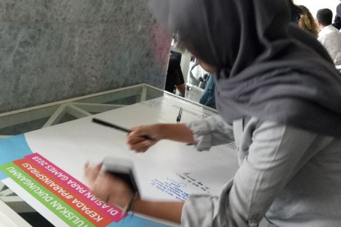 Pengunjung saat mengisi sebuah papan untuk mendukung atlet Indonesia di Para Games 2018