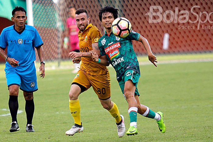 Striker Bhayangkara FC, Paulo Sergio (kiri), berebut bola dengan pemain PSS Sleman, Rangga Muslim, pada laga uji coba di Stadion Maguwoharjo, Sleman, Rabu (28/2/2018).