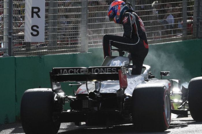 Pebalap tim Haas, Romain Grosjean, saat berusaha keluar dari mobilnya setelah gagal finis di GP Australia, Minggu (25/4/2018).