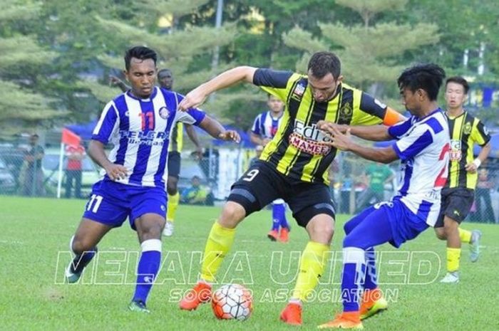 Striker Melaka United, Ilija Spasojevic diapit dua pemain Felcra FC pada laga uji coba di Stadion Hang Tuah, Sabtu (17/12/2016) sore.  