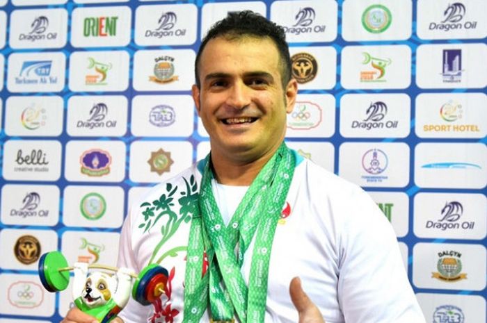 Lifter asal Iran, Sohrab Moradi, berpose dengan medali emas yang diraih pada Kejuaraan Dunia Angat Besi 2018.