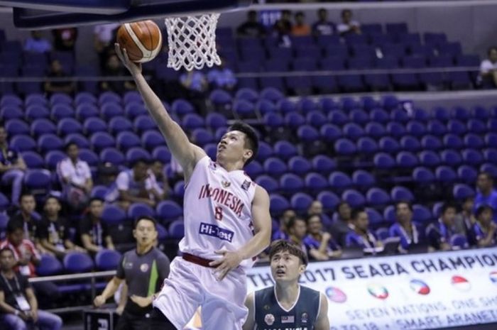 Shooting guard Indonesia, Abraham Damar Grahita (jersey putih, #8), melakukan lay-up setelah terlepas dari penjagaan pemain Malaysia, Chun Hong Ting, pada laga kedua SEABA 2017 di Smart Araneta Coliseum, Manila, Filipina, Sabtu (13/5/2017). Indonesia menang dengan skor 63-42.