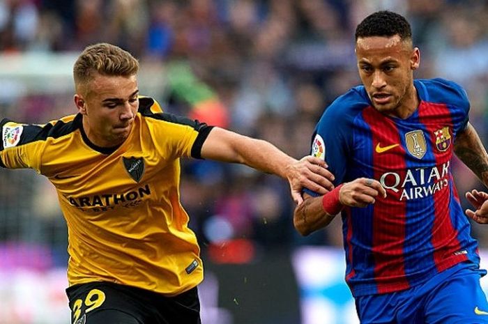 Pemain Barcelona, Neymar JR saat berebut bola dengan Pemain Malaga dalam pertandingan lanjutan La Liga di Camp Nou, 19 November 2016. 