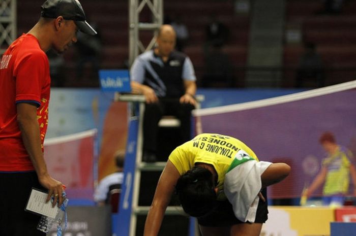 Pelatih tunggal putri junior Indonesia, Jeffer Rosobin (kiri), menghampiri Gregoria Mariska yang sedang sakit saat menjalani babak kelima Kejuaraan Dunia Junior 2017 di GOR Among Rogo, Yogyakarta, Kamis (19/10/2017).