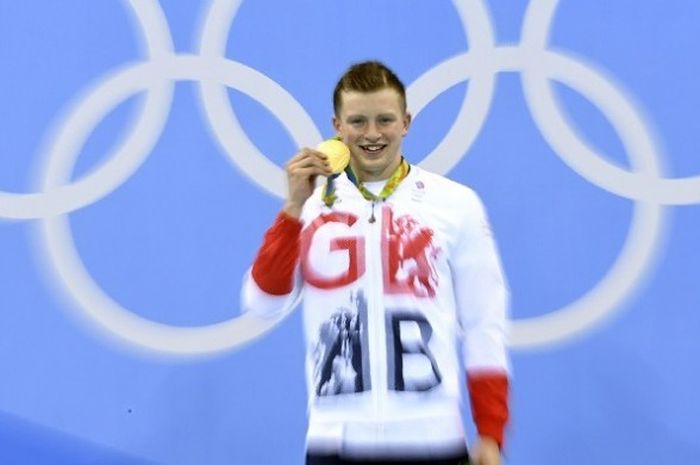 Perenang asal Britania Raya, Adam Peaty, berpose dengan medali emas yang diperolehnya dari nomor 100 meter gaya dada di Olympic Aquatics Stadium, Minggu (7/8/2016).