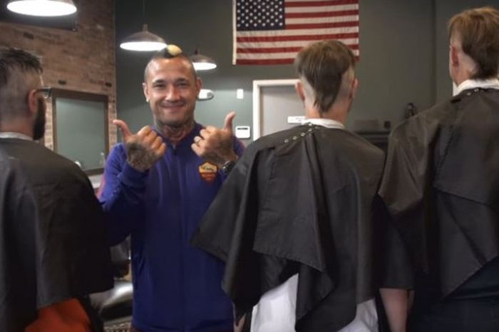 Bintang AS Roma, Radja Nainggolan berpose usai melakukan tantangan memotong rambut mohawk pada tiga orang pelanggan sebuah barbershop di Boston, Amerika Serikat.