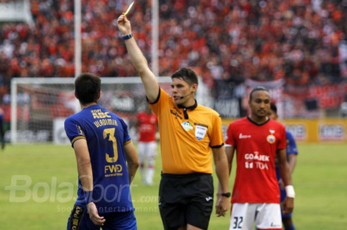 Wasit Evans Shaun Robert memberi kartu kuning kepada pemain Persib Bandung Vladimir Vujovic dalam duel di Stadion Manahan, Solo, Jumat (3/11/2017). 