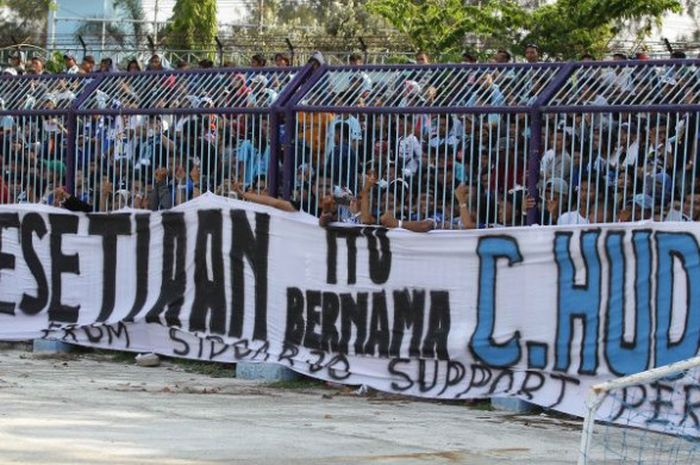 Spanduk dengan tulisan untuk menggenang Choirul Huda dibawa para penonton saat Persela menjamu Persib pada laga pekan ke-31 Liga 1 musim 2017 di Stadion Surajaya, Lamongan, Minggu (22/10/2017). 