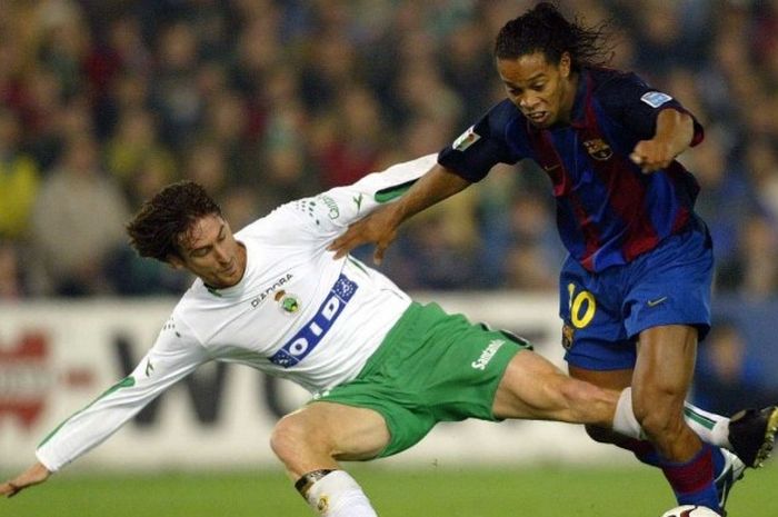 Ronaldinho berusaha melewati adangan pemain lawan dalam pertandingan La Liga, Barcelona kontra Racing Santander, 4 Januari 2004.