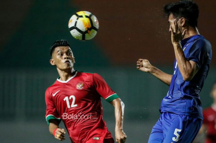 Penyerang timnas U-23 Indonesia, Lerby Eliandri berduel di udara dengan pemain timnas U-23 Thailand, Shinnaphat Leeaoh, di Stadion Pakansari, Kabupaten Bogor, Minggu (3/6/2018).