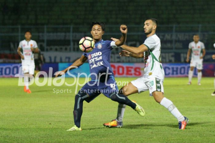 Pemain Arema FC Johan Alfarizie (tengah) berusaha mempertahankan bola dari hadangan gelandang PS TNI, Redouane Zerzouri (kanan). Arema dan PS TNI berakhir imbang 0-0 di Stadion Kanjuruhan, Malang, Sabtu (14/10/2017).