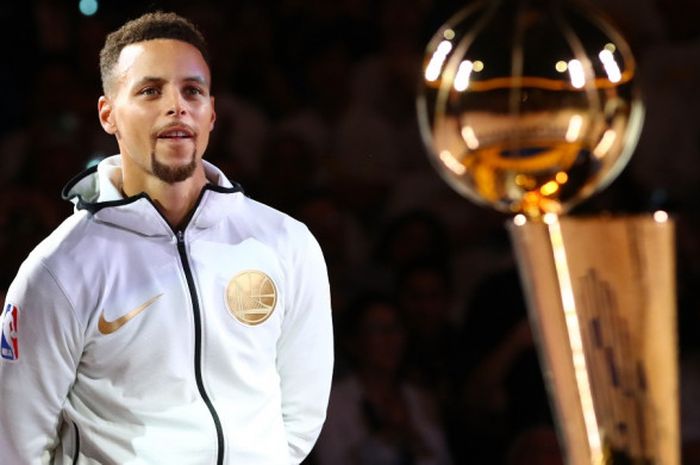 Pebasket bintang Golden State Warriors, Stephen Curry, bersiap menerima trofi NBA 2016-2017 yang diberikan sebelum laga melawan Houston Rockets di Oracle Arena, Oakland, California, Amerika Serikat, Selasa (17/10/2017).