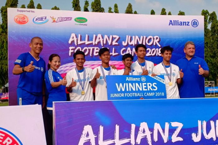 5 anak Jakarta (baju putih) yang berhasil terpilih menjadi yang terbaik dalam Allianz Junior Football Camp 2018 berpose bersama pelatih Nova Arianto (kiri), Head of Market Management Allianz Indonesia, Karin Zulkarnaen (kedua dari kiri), dan CEO Allianz Indonesia, Pieter Daniel van Zyl di Lapangan Simprug, Jakarta Selatan, pada Minggu (1/7/2018).