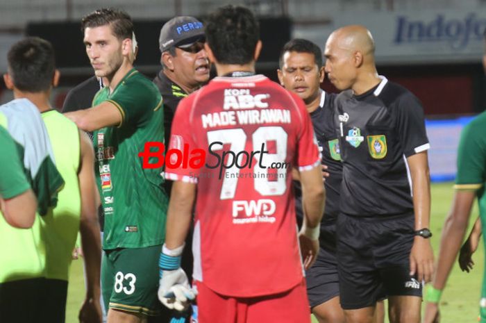 Wasit Suhardiyanto (berkepala plontos) mendapatkan protes dari kubu Persib saat mereka menjamu PSMS Medan  pada lanjutan Liga 1 2018 di Stadion Kapten I Wayan Dipta, Gianyar, 9 November 2018. 