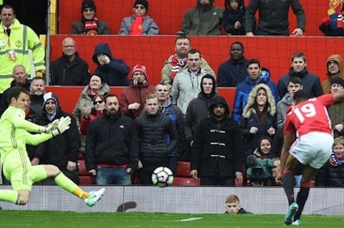 Kiper Chelsea, Asmir Begovic, gagal menahan tembahan penyerang Manchester United, Marcus Rashford, pada pertandingan Premier League di Stadion Old Trafford, Minggu (16/4/2017)