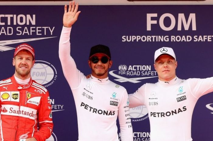 Pebalap Formula 1 (F1) yang membela tim Mercedes, Lewis Hamilton (tengah), berfoto bersama Sebastian Vettel dari tim Ferrari (kiri) dan rekan setim, Valtteri Bottas, seusai menjalani sesi kualifikasi GP China di Sirkuit Shanghai Internasional, Sabtu (8/4/2017). Hamilton meraih pole position setelah mencatat waktu putaran tercepat 1 menit 31,678 detik.