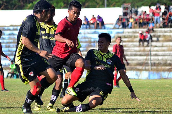 Pemain PS Mojokerto, Putera Indra Setiawan (tengah), berupaya melewati hadangan pemain Kalteng Putra dalam laga lanjutan Liga 2 di Stadion Gajah Mada, Mojosari, Jawa Timur, Minggu (06/05/2018) sore.