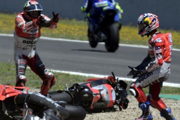 Dua pebalap Ducati, Jorge Lorenzo (kiri) dan Andrea Dovizioso (kanan) tampak saling berargumen usai terlibat insiden pada balapan MotoGP Spanyol 2018 yang digelar Minggu (6/5/2018).  