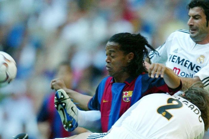 Ronaldinho berusaha lepas dari kawalan Luis Figo (atas) dan Michel Salgado dalam partai Liga Spanyol antara Real Madrid dan Barcelona di Santiagio Bernabeu, Madrid, 25 April 2004.