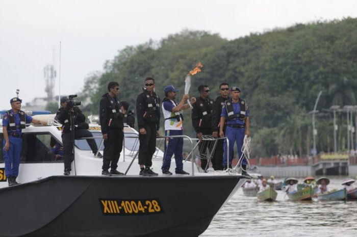 Kirab obor Asian Games 2018 saat tiba di Banjarmasin, Kalimantan Selatan, dengan menggunakan kapal Dewarucci, Senin (30/7/2018).