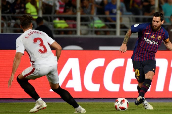 Megabintang FC Barcelona, Lionel Messi (kanan), melepaskan umpan dalam laga Piala Super Spanyol kontra Sevilla di Grande Stade de Tanger, Tangiers, Maroko pada 12 Agustus 2018.