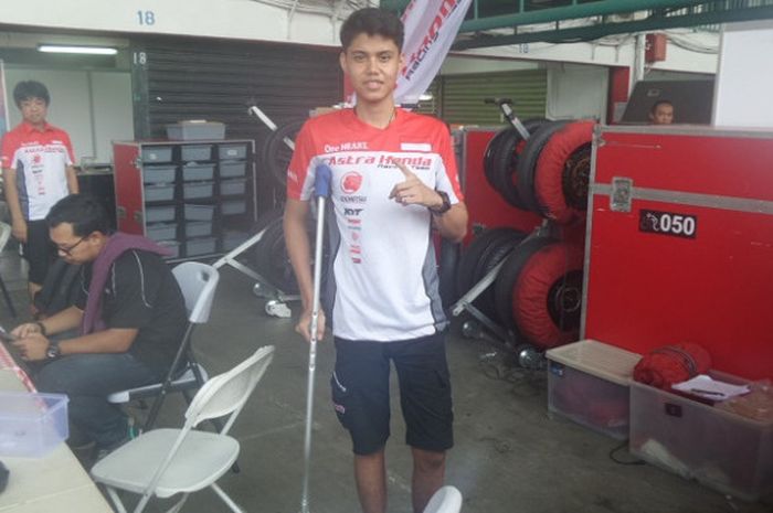Pebalap Astra Honda Racing Team, Irfan Ardiansyah, berpose di paddock timnya di Sirkuit Sentul, Kabupaten Bogor, Jumat (11/8/2017). Ia masih harus menggunakan tongkat kruk karena cedera patah tulang kering kaki kiri.