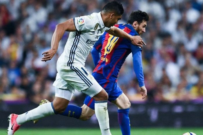 Striker Barcelona, Lionel Messi (kanan), beradu lari dengan gelandang Real Madrid, Casemiro, dalam pertandingan Liga Spanyol 2016-2017 di Estadio Santiago Bernabeu, Madrid, Spanyol, pada Minggu (23/4/2017).
