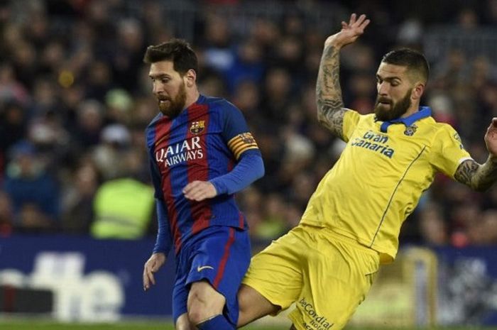 Striker Barcelona Lionel Messi dikawal ketat oleh pemain Las Palmas, Marko Livaja yang berusaha menjegalnya di laga Liga Spanyol pada 14 Januari 2017.